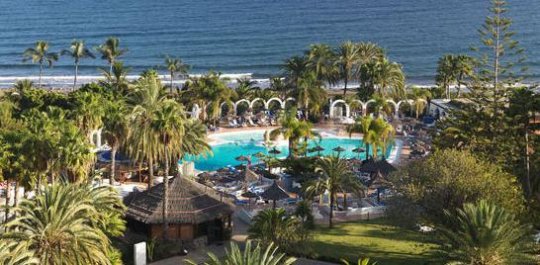 Vista de piscina y jard&iacute;nes