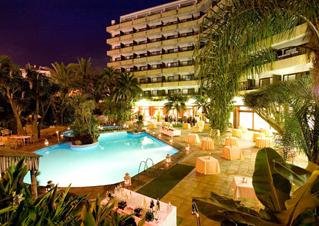 Vista nocturna de la piscina y hotel